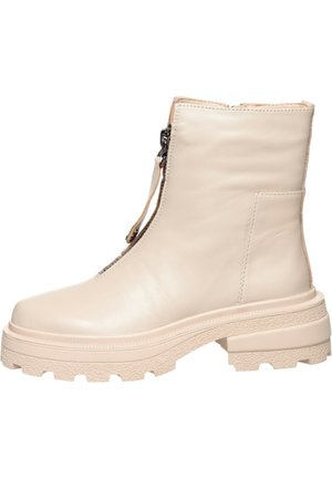 Bottine beige en cuir avec semelle épaisse texturée et fermeture éclair à l'avant.
