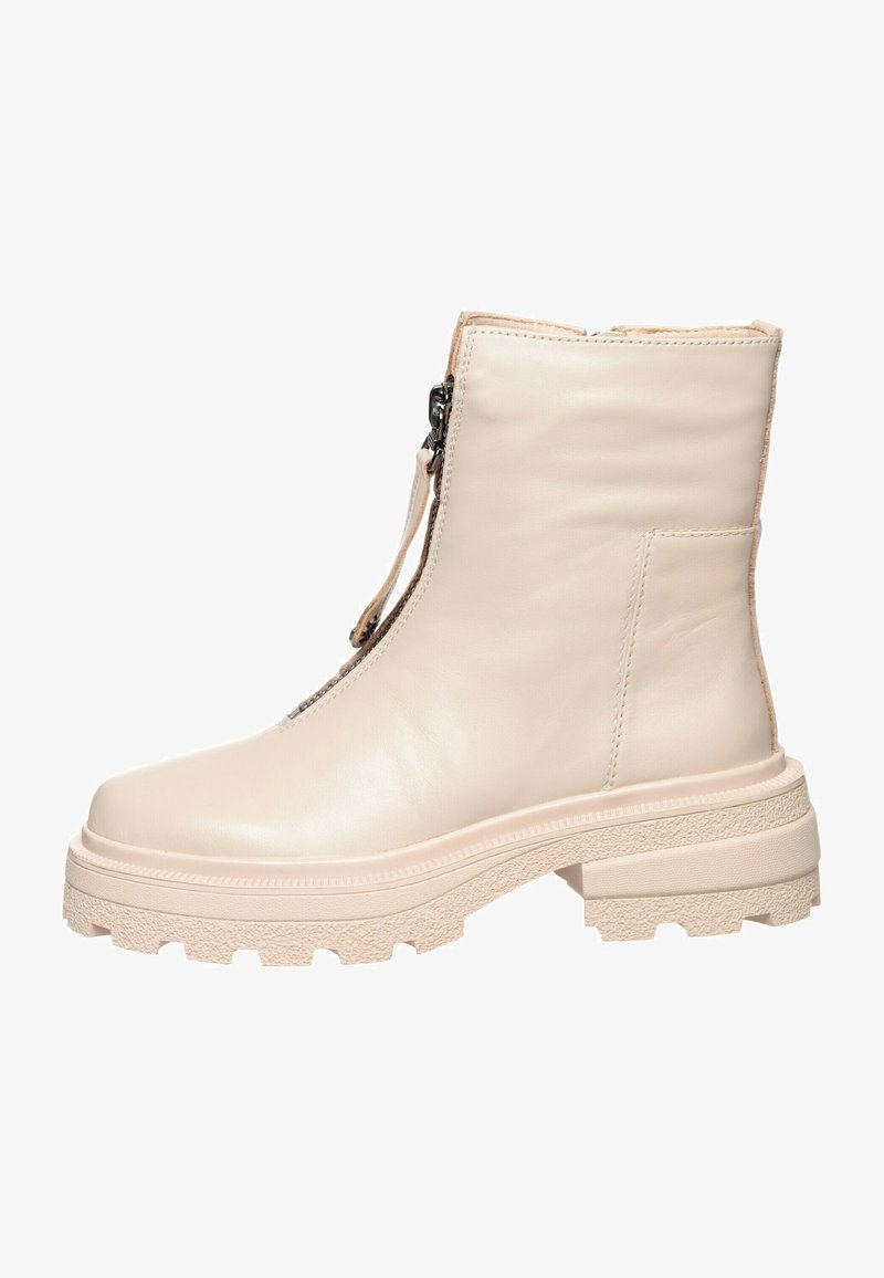 Bottine beige en cuir avec semelle épaisse texturée et fermeture éclair à l'avant.