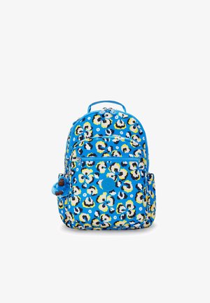 Zaino blu con una stampa floreale a motivo leopardato in giallo, nero e bianco. Ha cerniere, una maniglia e un portachiavi a forma di scimmia attaccato.