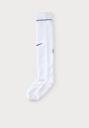 Calcetín blanco simple hasta la rodilla con una raya negra cerca de la parte superior y un pequeño logo negro en el lateral.