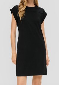 Mustassa lyhythihaisessa mekossa on pyöreä pääntie, rento istuvuus ja sileä kangas, joka ulottuu reiden puoliväliin. Yksinkertainen muotoilu.