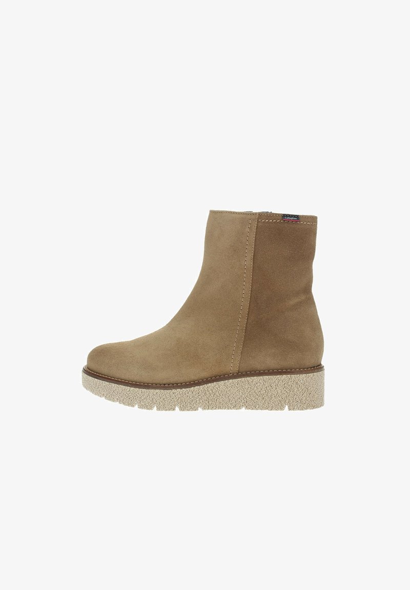Botas de tobillo de ante color marrón claro con punta redondeada, paneles elásticos en los laterales y suela de goma texturizada. El diseño cuenta con una cuña baja para añadir altura.