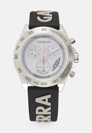 Chronograph-Uhr mit einem Gehäuse aus silberfarbenem Edelstahl, grauem Gummiband mit geprägtem Logo und einem strukturierten, grauen Zifferblatt mit Unterzifferblättern.