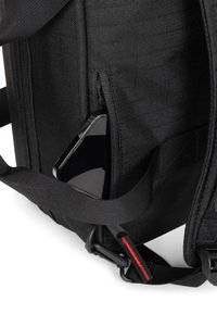 Bolso de hombro de tela negra con un bolsillo con cremallera que sostiene un teléfono inteligente. Material texturizado y correa resistente con un acento rojo.