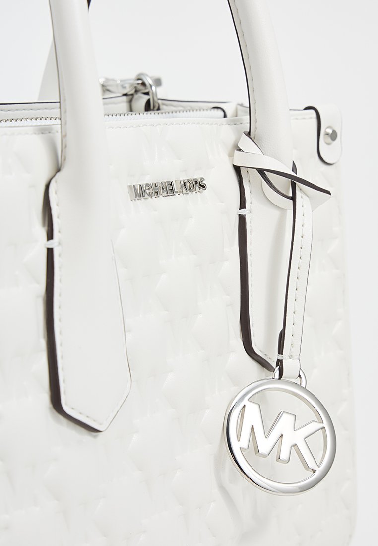 Weißes strukturiertes Lederhandtasche mit doppelten Griffen, silberner Hardware und einem rundem Logo-Anhänger. Besitzt ein Logo-Emblem und zarte Nähte.