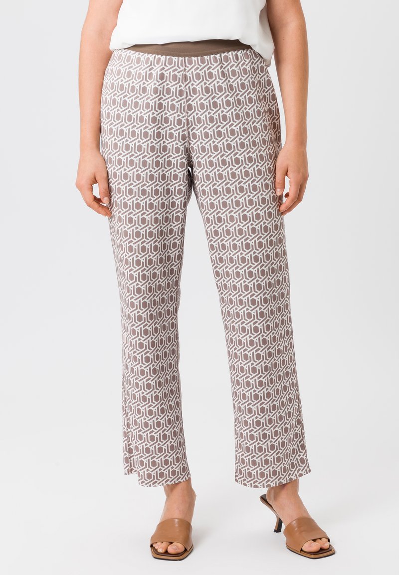 Pantalons à motifs en marron clair avec un design géométrique. Dotés d'une taille élastique confortable et d'une coupe de jambe ample. Texture de tissu lisse.