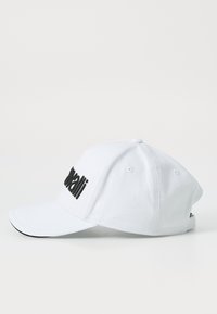 Hvit baseballcaps laget av bomull med buet skygge, med svart brodert tekst foran og en knapp på toppen.