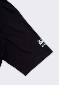 Maglietta nera a maniche corte con un logo grafico bianco sul lato sinistro della manica. Realizzata in cotone, ha una superficie liscia e una vestibilità standard.