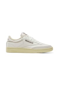 Fehér bőr tornacipő krém színű gumitalppal. A Reebok logó a cipő oldalán található, valamint textúrázott díszek a lábujjnál és a saroknál.