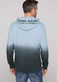 Sudadera con capucha en un degradado de azul claro a verde oscuro. Presenta el texto "CAMP DAVID" en negro en la parte trasera, puños y dobladillo acanalados.