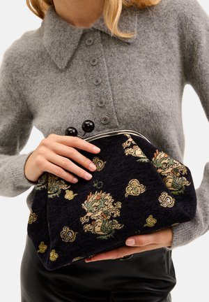 Svart tyg-handväska med blommig broderidetalj, silverfäste och svarta sfäriska accenter. Mjuk textur, rundad form.