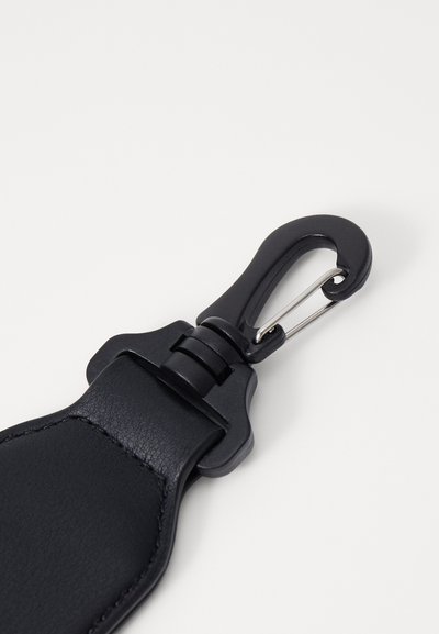 Dragonne de porte-clés en cuir noir avec un mousqueton pivotant, des coutures renforcées et une texture lisse. Design compact et fonctionnel.