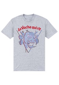 Šedé tričko s krátkým rukávem, na kterém je grafický design s tváří krávy a červenými a modrými pruhy. Text nahoře zní "La Vache qui rit."