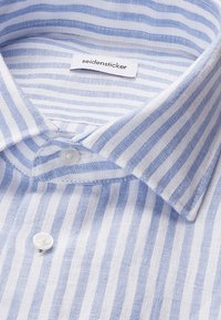 Chemise à rayures verticales bleu clair et blanc, boutonnée, avec col classique et étiquette de marque « seidensticker » à l’intérieur du col.