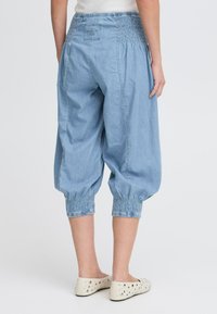 Svijetloplave chambray culotte s elastičnim pojasom, skupljenim manžetama i ležernim krojem, upotpunjuju ležeran izgled.