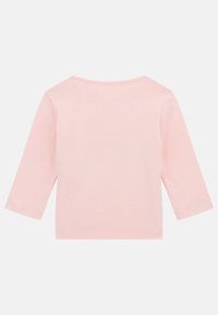 Helles rosa langärmliges Oberteil aus weicher Baumwolle, mit rundem Halsausschnitt und nahtlosen Schultern. Keine sichtbaren Muster oder Akzente.