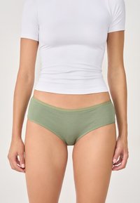 Zielone majtki z prążkowanej tkaniny, z miękkim elastycznym paskiem w talii, charakteryzujące się prostym designem i dopasowanym, wysokim krojem.