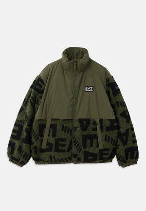 Olive zelena jakna s zip ovratnikom, z črnimi flis rokavi z geometrijskimi vzorci, nastavljivo vrvico in logotipom na prsih.