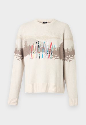Krēmkrāsas dzijas džemperis ar brūnu kalnu un meža rakstu un krāsainām izšūtām slēpēm pāri krūtīm.