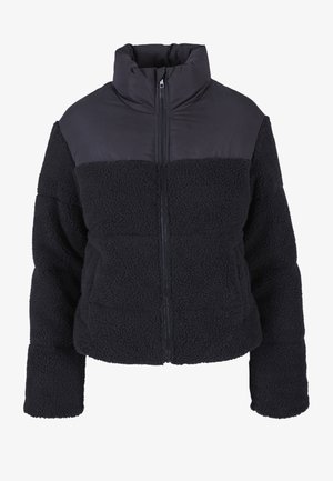 Juoda vilnos striukė su lygiu juodu medžiagos viršutiniu skyriumi. Yra priekyje užtrauktukas, aukštas apykaklis ir dvi priekinės kišenės. Visas gaminys yra tekstūruotos medžiagos.