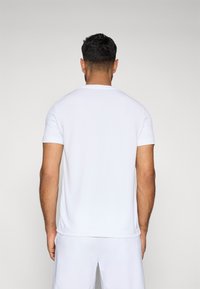 Witte T-shirt met korte mouwen en ronde hals, met een gladde textuur, rechte zoom en minimale details, gezien vanaf de achterkant.