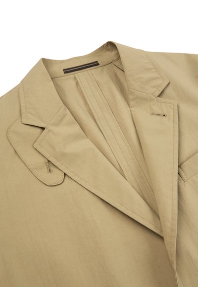 Beige blazer met inkeping revers, knoopsgat-details op de kraag en een gladde, fijne stoftextuur, afgebeeld op een witte achtergrond.