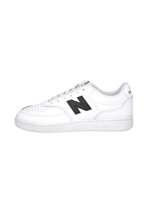 Zapatilla blanca New Balance de perfil bajo con logo "N" negro en el lateral, diseño con cordones y puntera perforada para ventilación.