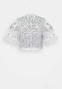Veste courte à manches courtes en tissu blanc ornée de sequins argentés, broderies complexes et accents à volants sur les manches.