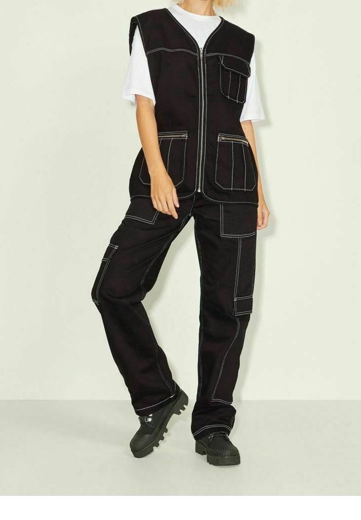 Svart arbetsklädsel bestående av en zip-up väst med flera fickor och kontrasterande sömmar, ihopparad med matchande byxor och kraftiga svarta skor.