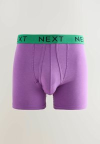 Boxer-briefs violets avec une large ceinture verte étiquetée "NEXT." Fabriqués en tissu doux, présentant une coupe ajustée et un design à couture plate.