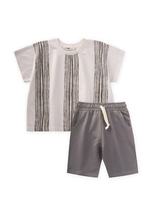 Weißes Baumwoll-T-Shirt mit braunen vertikalen Streifen, kombiniert mit grauen Shorts mit elastischem Bund und Taschen.