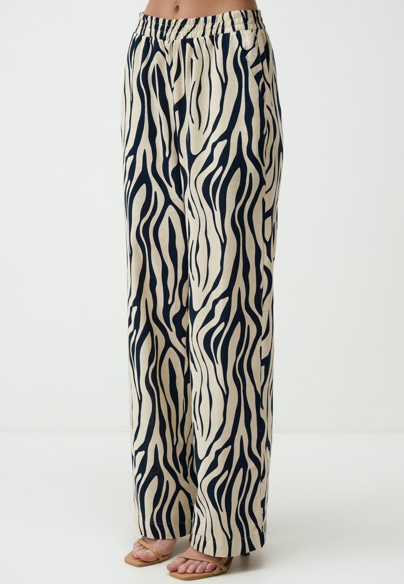 Linnenmix wijde broek in een beige achtergrond met zwarte zebraprinten, elastische tailleband en zijzakken.