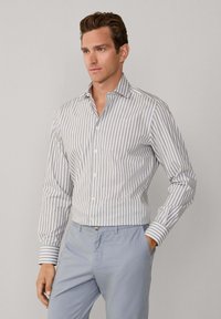 Gestreiftes Hemd in Hellgrau und Weiß, aus Baumwollmaterial, taillierter Schnitt, geknöpfte Front, mit langen Ärmeln und einem Kentkragen.