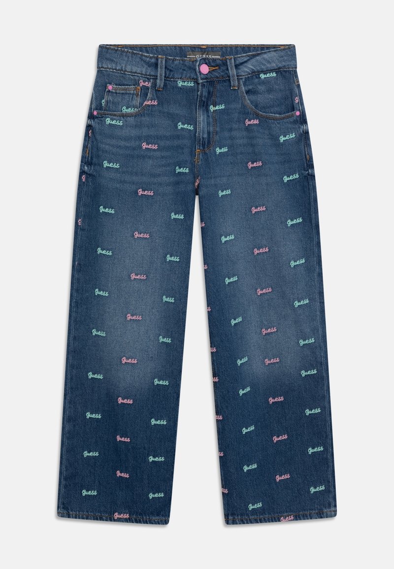 Jean bleu foncé à jambes larges avec de petits logos « Guess » roses et bleu clair imprimés partout et fermeture par bouton rose.