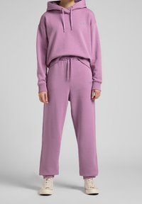 Lila hoodie met kangoeroezak en koord, gecombineerd met bijpassende joggers met een elastische tailleband en cuffs. Gelaagd stof.