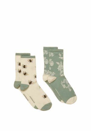 Dwie pary skarpetek do połowy łydki: jedna kremowa z wzorami pszczół oraz zielonymi palcami i mankietami, druga zielona z kremowymi kwiatowymi wzorami i palcami.