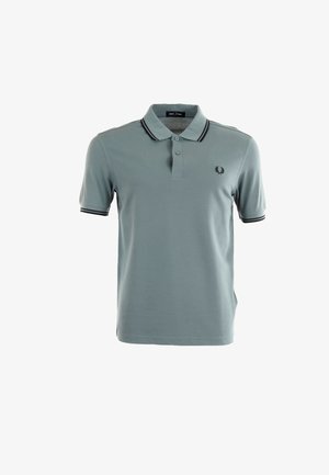 Camisa polo azul claro con cuello, tapeta de tres botones y puños de manga con rayas en azul marino. Logo bordado en el pecho.