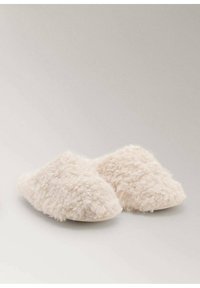 Pantofole bianche pelose con una texture morbida, dotate di un design a calzata e punta arrotondata. Nessun hardware o motivo visibile.
