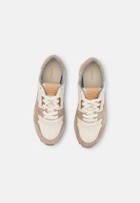 Paire de baskets GANT beige et blanches avec lacets, vue de dessus sur un fond blanc uni.