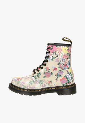 Floral-patterned lace-up ankle boots in beige synthetic material with black accents and yellow stitching. Features a sturdy black sole.
