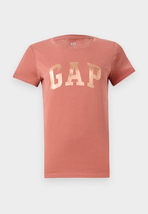Kortermet, støvet rosa t-skjorte for kvinner med metallisk rosegull "GAP"-logo sentrert på brystet, rund hals og enkel søm.