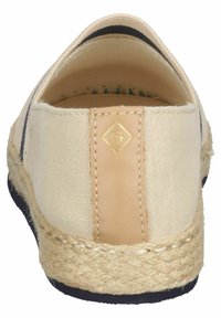 Beige kanvas espandrillos med en naturlig jutesula, utrustade med en gulllogodetalj på tanfärgad tyg och en låg baksidedesign.
