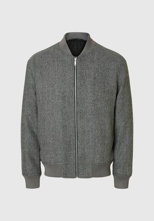 Grijze herringbone bomberjack met een rits aan de voorkant, ribbelkraag, manchet en onderrand. Beschikt over een gladde, textuurstof.
