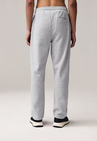 Gray sweatpants with a relaxed fit, elastic waistband, and single back pocket. Made from soft fabric, featuring a smooth texture and straight leg design.