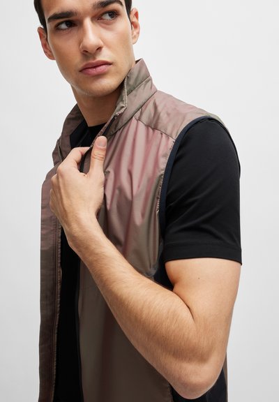 Gilet sans manches dans un dégradé de rose pastel et gris, réalisé en matière lisse et légère avec un col haut et des zips.