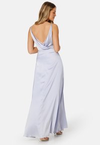 Abito maxi in satin blu chiaro con schiena drappeggiata, spalline sottili e un accento in pizzo. Silhouette fluida con una texture liscia.