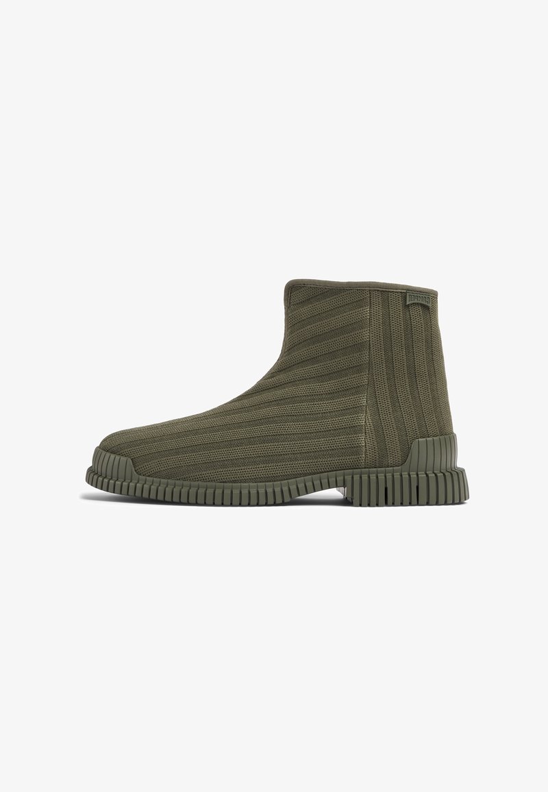 Bottine cheville vert olive foncé avec texture tricot côtelé et semelle épaisse rainurée, vue de côté, montrant un bout arrondi et un talon rembourré.