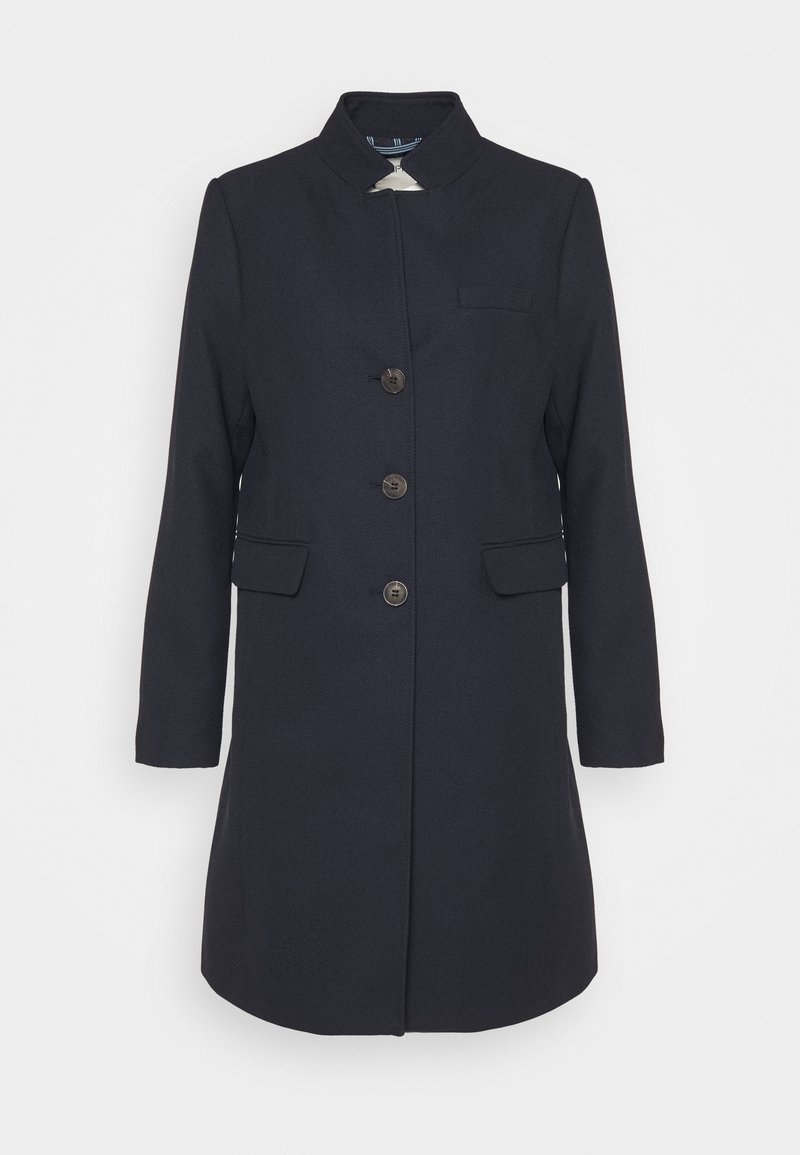 Mörkblå kappa i texturerad tyg, med hög krage, framknäppning med knappar, två sidofickor och en bröstficka.
