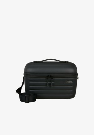 Kompakter schwarzer Samsonite Hardshell-Reisekoffer mit Doppelreißverschluss, oberem Griff und verstellbarem, abnehmbarem Schultergurt vor weißem Hintergrund.