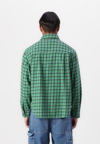 Green and blue plaid button-up shirt with long sleeves, featuring a relaxed fit and a back yoke detail. Lightweight fabric texture.